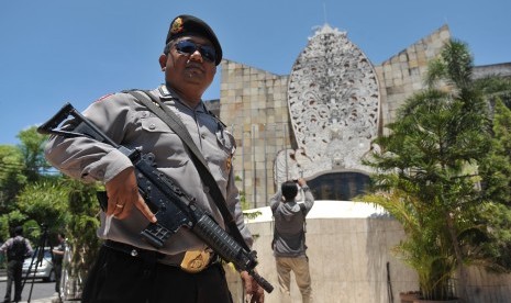 Seorang polisi mengawasi aktifitas wisatawan dan masyarakat di kawasan Monumen Bom Bali, Kuta, Jumat (15/1). (Antara/Nyoman Budhiana)