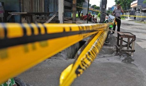 Seorang polisi menjaga warung TKP penembakan Fransiskus Refra (Tito Kei) di perumahan Taman Tytian Indah, Medan Satria, Bekasi, Sabtu (1/6). 