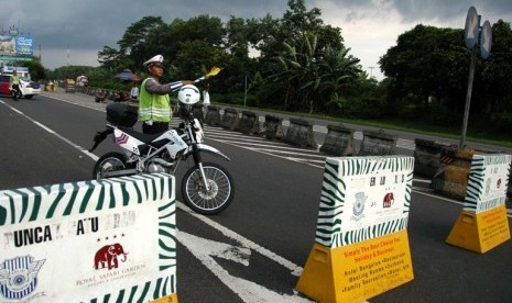 Seorang Polisi menutup jalur menuju kawasan Puncak. Dinas Bina Marga Jabar memperbaiki jalan di daerah wisata menjelang libur Nataru.