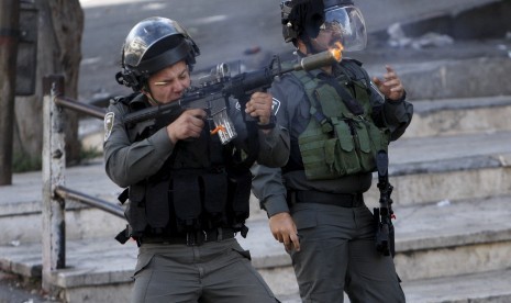 Seorang polisi perbatasan Israel menembakkan peluru karet di pengunjuk rasa Palestina dalam bentrokan di Yerusalem al-Aqsa, di kota Tepi Barat yang diduduki Hebron 29 September 2015.