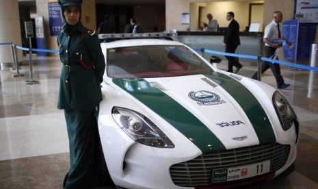 Seorang polisi wanita berdiri di dekat mobil Mercedes yang digunakan oleh kepolisian Dubai.     (Reuters/Ahmed Jadallah)