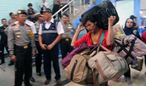 Seorang porter membawa barang bawaan penumpang di pelabuhan Bakauheni Lampung Selatan, Lampung, Kamis (22/6). Puncak arus mudik di pelabuhan itu diperkirakan terjadi pada H-3 malam hari.