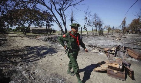 Seorang prajurit berjalan di tengah puing perkampungan Pauktaw yang dibakar dalam kekerasan baru-baru di Rakhine, Myanmar (Ilustrasi)