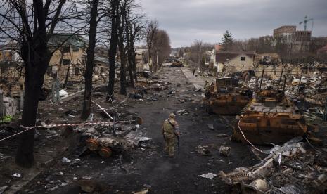 Seorang prajurit Ukraina berjalan di tengah tank Rusia yang hancur di Bucha, di pinggiran Kyiv, Ukraina, 6 April 2022.