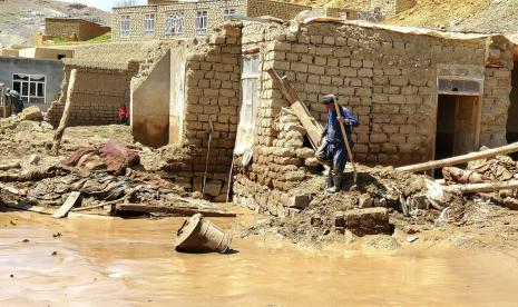 Seorang pria Afghanistan mengambil barang-barangnya dari rumahnya yang rusak setelah banjir besar di provinsi Ghor di Afghanistan barat, Sabtu, 18 Mei 2024. Banjir bandang akibat hujan lebat musiman di provinsi Ghor menewaskan puluhan orang dan puluhan lainnya hilang, kata seorang pejabat Taliban di Sabtu, menambahkan jumlah korban tewas didasarkan pada laporan awal dan mungkin bertambah.