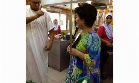 Seorang pria Arab menasehati wanita yang mengenakan pakaian bertuliskan ayat Alquran.