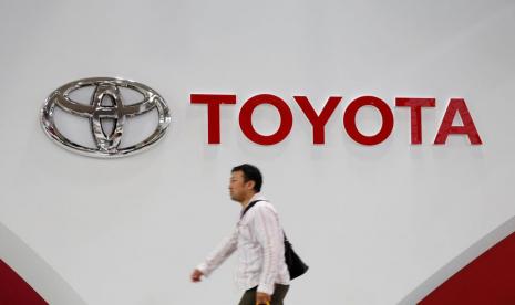 Seorang pria berjalan melewati logo Toyota Motor Corp di showroom perusahaan di Tokyo, Jepang 14 Juni 2016.