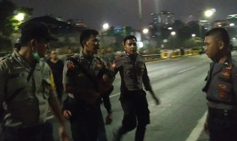 Seorang pria berpakaian hitam ditangkap petugas di Jalan Gatot Subroto, Jakarta, Rabu (25/9) malam.