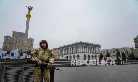 Seorang pria bersenjata berdiri di Lapangan Independen (Maidan) di pusat Kyiv, Ukraina, Rabu, 2 Maret 2022. Pemimpin Ukraina mengecam eskalasi serangan Rusia di kota-kota padat sebagai kampanye teror terang-terangan, sementara Presiden Joe Biden memperingatkan bahwa jika Pemimpin Rusia tidak membayar harga untuk invasi, agresi tidak akan berhenti di satu negara.