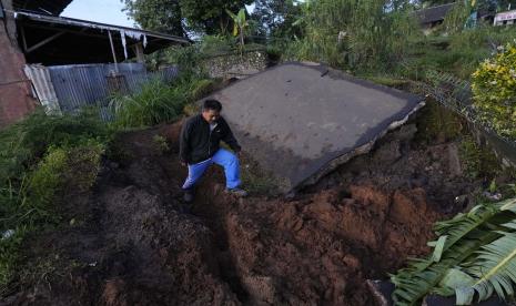 Seorang pria melewati jalan yang rusak parah akibat gempa Senin di Cianjur, Jawa Barat, Indonesia, Kamis, 24 November 2022. Gempa bermagnitudo 5,6 menyebabkan ratusan orang tewas, luka-luka, dan hilang saat bangunan runtuh dan penduduk yang ketakutan lari menyelamatkan diri. pulau utama Jawa. 