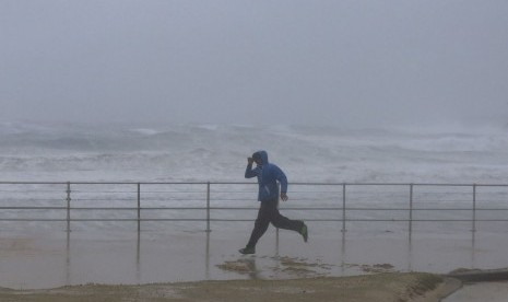 Seorang pria melewati Pantai Bondi, Sydney yang sedang pasang