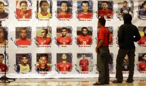 Seorang pria melihat foto pemain Timnas U 19.