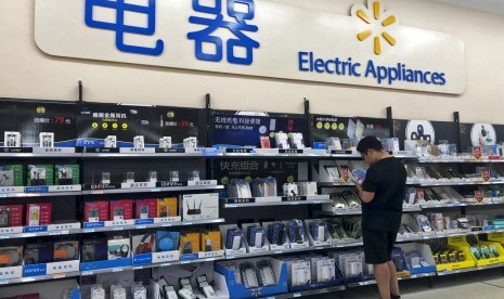 Seorang pria melihat-lihat spesifikasi power bank di sebuah supermarket di Beijing, Kamis (9/5). Ketegangan antara AS dan Cina telah mendorong Presiden Donald Trump meningkatkan tarif impor barang Cina.