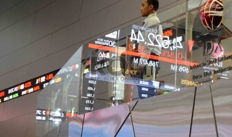 Seorang pria melihat monitor saham di Bursa Efek Indonesia, Jakarta (ilustrasi). Puluhan emiten di BEI melakukan buyback saham.