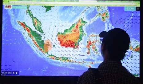 Seorang pria melihat peta titik api (hot spot) di Posko Kebakaran Lahan dan Hutan Kementerian Lingkungan Hidup dan Kehutanan, Jakarta, Selasa (22/9).