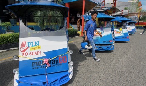 Seorang pria melintas diantara Becak motor (bentor) MootilanGo (motor uti pelayan Gorontalo) yang diluncurkan di kantor PLN area Gorontalo, Gorontalo, Senin (10/4).