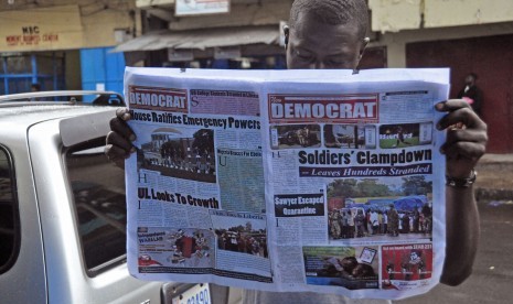 Seorang pria membaca suratkabar yang halaman depannya memuat mengenai wabah ebola di Monrovia, Liberia, Jumat (8/8) 