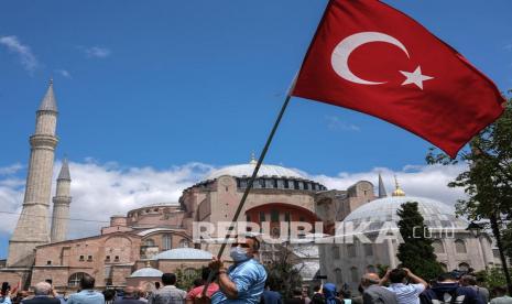  Seorang pria membawa bendera Turki di depan Masjid Hagia Sophia 