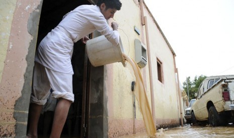    Seorang pria membuang air dari rumahnya yang terendam banjir usai hujan lebat di Tabuk,Arab Saudi,Senin (28/1).   (Reuters/Mohamed Alhwaity)