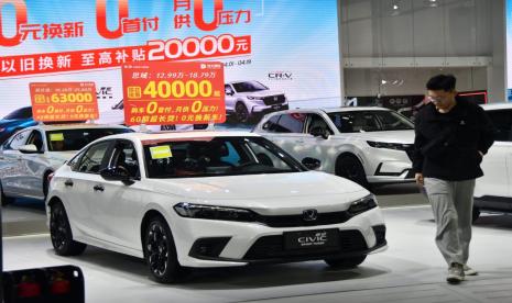 Seorang pria memeriksa sedan Honda Civic di acara promosi barang lama untuk barang baru di Handan, provinsi Hebei, pada bulan April. 