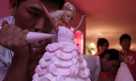 Seorang pria mendekorasi kue boneka Barbie di Cafe Barbie di Taipei, Rabu (30/1).  (Reuters/Pichi Chuang)