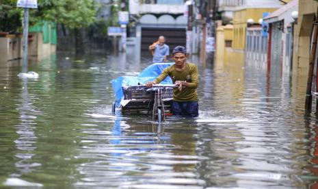 Seorang pria mendorong gerobaknya melewati air banjir di Sylhet, Bangladesh, Senin, 20 Juni 2022. Banjir di Bangladesh terus mendatangkan malapetaka pada hari Senin dengan pihak berwenang berjuang untuk mengangkut air minum dan makanan kering ke tempat penampungan banjir di seluruh wilayah utara dan timur laut yang luas di negara itu.