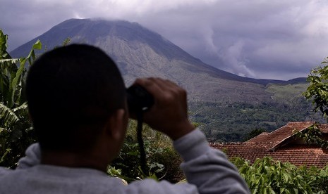 Seorang pria mengamati asap putih mengepul dari Kawah Tompaluan yang berada yempat disamping Gunung Lokon, Tomohon, Sulawesi Utara, Minggu (10/1).