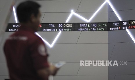 Seorang pria mengamati layar pergerakan indeks harga saham gabungan (IHSG) di gedung Bursa Efek Indonesia, Jakarta, Jumat (5/4).