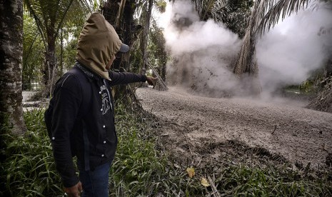 Seorang pria menunjuk ke arah semburan lumpur di Kelurahan Tondangouw, Tomohon Selatan, Sulawesi Utara, Senin (28/12).