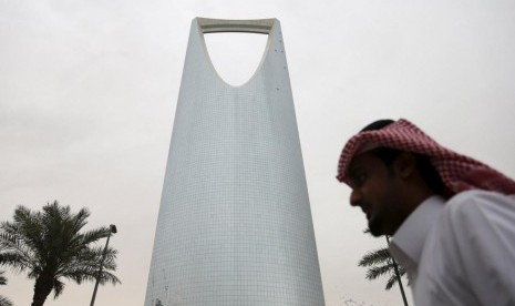 Warga Asing Kini Bisa Mengelola Perusahaan Milik Saudi. Seorang pria Saudi berjalan melewati Kingdom Centre Towerdi Riyadh, Arab Saudi.