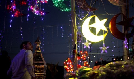 Seorang pria Yordania melihat dekorasi hiasan lampu untuk Ramadhan di Amman, Yordania, Kamis (19/7). (Mohammad Hannon/AP)