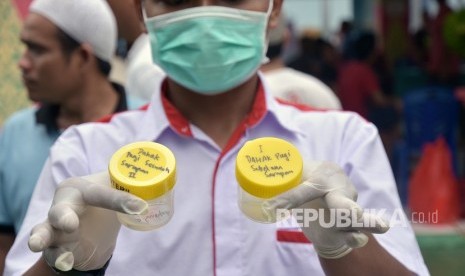 Petugas menunjukkan botol berisi dahak yang dikumpulkan dalam edukasi dan screening TBC. (Dok)