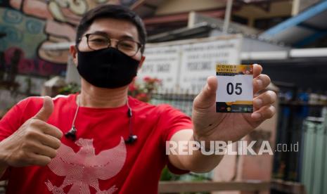 Seorang relawan menunjukkan no antrean uji klinis Vaksin COVID-19 usai pemeriksaan kesehatan di Puskesmas Dago, Bandung, Selasa (11/8/2020). 