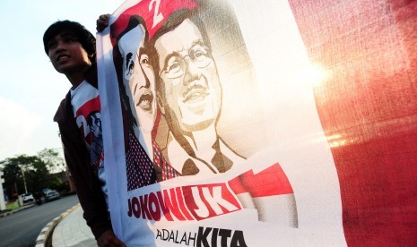 Seorang relawan pendukung Capres/Cawapres, Jokowi dan Jusuf Kalla, melakukan aksi damai untuk memperkenalkan kiprah Jokowi di Bundaran Digulis, Pontianak, Kalbar, Sabtu (5/7). 