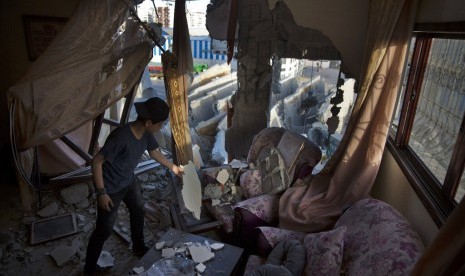 Seorang remaja Palestina di rumahnya yang hancur akibat serangan udara Israel di Gaza City, Palestina, Senin (6/5).