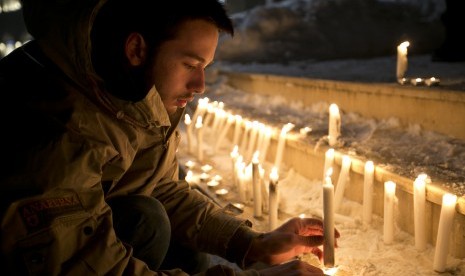 Seorang simpatisan menyalakan lilin sebagai bentuk solidaritas terhadap korban penembakan kantor majalan Charlie Hebdo di Paris, Prancis