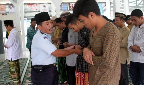 Seorang sipir pembina melatih narapidana menunaikan ibadah salat saat kegiatan Pondok Ramadan di Rumah Tahanan (Rutan) Klas IIB Trenggalek, Jawa Timur, Senin (22/6).