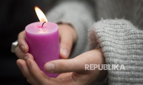 Seorang siswa memegang lilin saat peringatan untuk mengenang korban penembakan di luar Masjid Al Noor di Christchurch, Selandia Baru, Senin (18/3/2019).