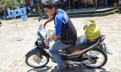   Seorang siswa mengemudikan sepeda motor berbahan bakar gas elpiji ukuran 3kg karya siswa SMKN 8 Bandung di halaman SMKN 4, Jl Kiliningan, Bandung, Kamis (31/10).  (Republika/Edi Yusuf)