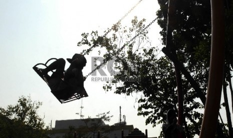 Seorang siswa SD Nampak bermain ayunan di Taman Menteng Jakarta, Senin (5/10).