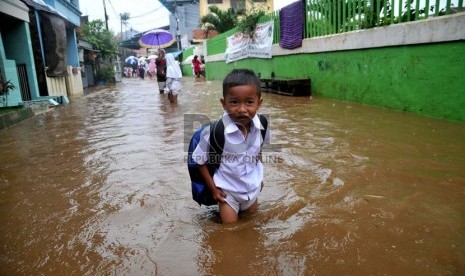   Seorang siswa SD pulang sekolah melintasi banjir/ilustrasi (Republika/Prayogi)