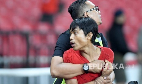 Seorang suporter Indonesia (kanan) diamankan petugas seusai berusaha menyerang suporter Malaysia saat pertandingan timnas Indonesia melawan timnas Malaysia pada Kualifikasi Piala Dunia 2022 Grup G Zona Asia di Stadion Gelora Bung Karno (GBK), Senayan, Jakarta, Kamis (5/9/2019). 