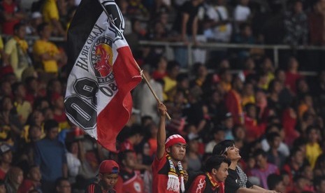 Seorang suporter tim Semen Padang mengibarkan bendera klubnya saat laga Final Piala Jenderal Sudirman di Stadion Utama Gelora Bung Karno, Jakarta, Ahad (24/1).