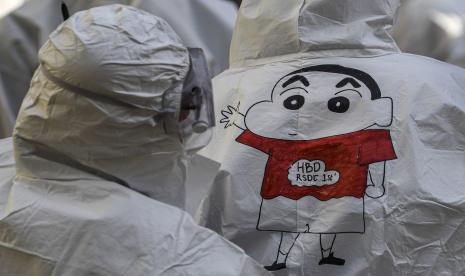 Seorang tenaga kesehatan melihat gambar karikatur Crayon Shinchan di hazmat rekannya. (ilustrasi)