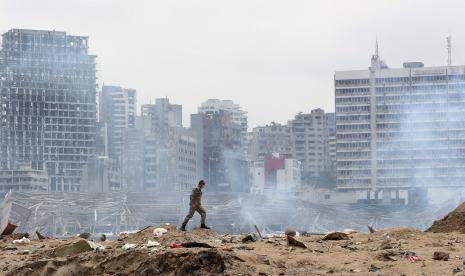  Seorang tentara berjalan di lokasi ledakan yang hancur di pelabuhan Beirut, Lebanon, Kamis 6 Agustus 2020. 