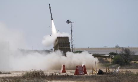  Seorang tentara Israel berlindung saat sistem pertahanan udara Iron Dome diluncurkan untuk mencegat roket yang ditembakkan dari Jalur Gaza, di Ashkelon, Israel selatan, Ahad, 7 Agustus 2022. Israel telah membunuh dua militan senior Jihad Islam dalam tiga hari penerbangan serangan di Jalur Gaza, dan militan Palestina telah meluncurkan hampir 600 roket ke Israel. Para pejabat Palestina mengatakan sedikitnya 31 orang di Gaza telah tewas.