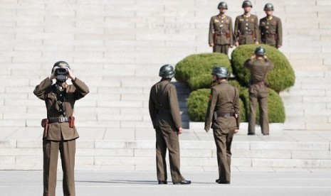 Seorang tentara Korea Utara melihat Desa Panmunjom di Paju, Korea Selatan yang berbatasan dengan Korut melalui teropong.