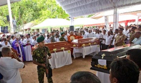 Seorang tentara menjagaupacara pemakaman yang dihadiri Kardinal Malcolm Ranjith bagi korban serangan bom di Gereja St. Sebastian di Negombo, Sri Lanka, Selasa (23/4). 