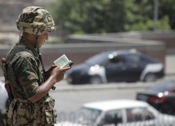 Seorang tentara Mesir membaca Al Quran, ketika bertugas menjaga masjid Al Azhar di Kairo, Mesir. (AP)