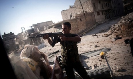   Seorang Tentara Pembebasan Suriah dalam posisi menembak di sebuah jalan di distrik Amariya Aleppo, Suriah, Senin (10/9).    (Manu Brabo/AP)